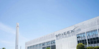 SpaceX building with rocket and palm tree outside