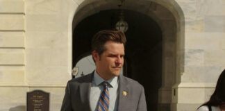 Man in suit walking outside stone building