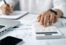 Retirement ‘Magic Number’ Myth Exposed A person using a calculator while taking notes in a business setting