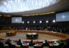 Conference room with large round table and attendees