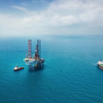 Trump Claims 65 Billion Barrels of Oil – Locked Oil rig surrounded by ships in the ocean.