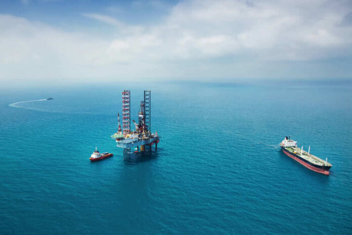 399936280 Oil rig surrounded by ships in the ocean.