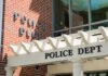 Police department building with brick facade and signage.