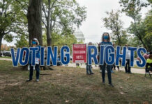 People holding Voting Rights sign near the Capitol building.