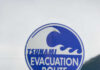 Sign indicating tsunami evacuation route with a wave graphic