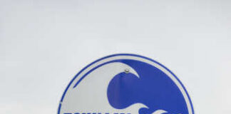 Sign indicating tsunami evacuation route with a wave graphic