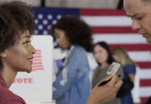 A woman showing her ID to a man at a voting station