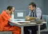 Clown Mask Murder Shocker A detective interrogating a prisoner in an orange jumpsuit at a table