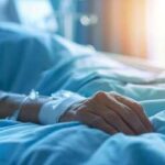 Hero Dad’s Split-Second Dive, Unthinkable Aftermath A patient's hand resting on a hospital bed with an IV line attached