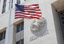 American flag waving in front of a United States court house