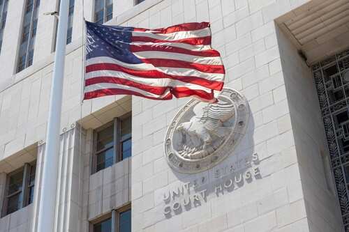 American flag waving in front of a United States court house