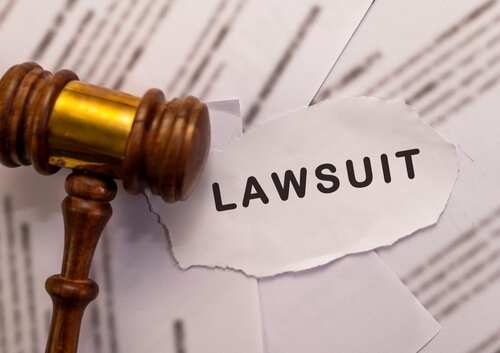 Wooden,Gavel,And,Torn,Paper,With,"lawsuit",Text.,Legal,Action, A wooden gavel next to a torn paper with the word 'LAWSUIT'