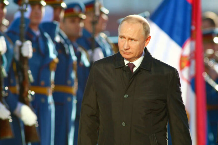 A political figure walking past a military honor guard during a ceremony