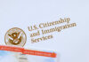 U.S. Citizenship and Immigration Services logo with document.