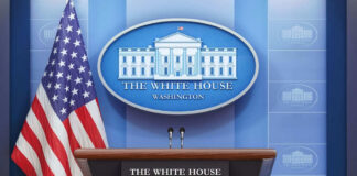 Podium with microphones in front of American flag