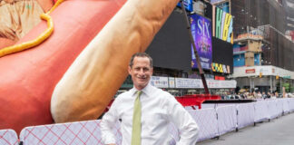 Man standing in front of large hotdog sculpture