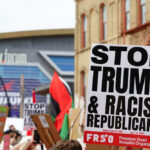 Protest signs against Trump at outdoor rally event