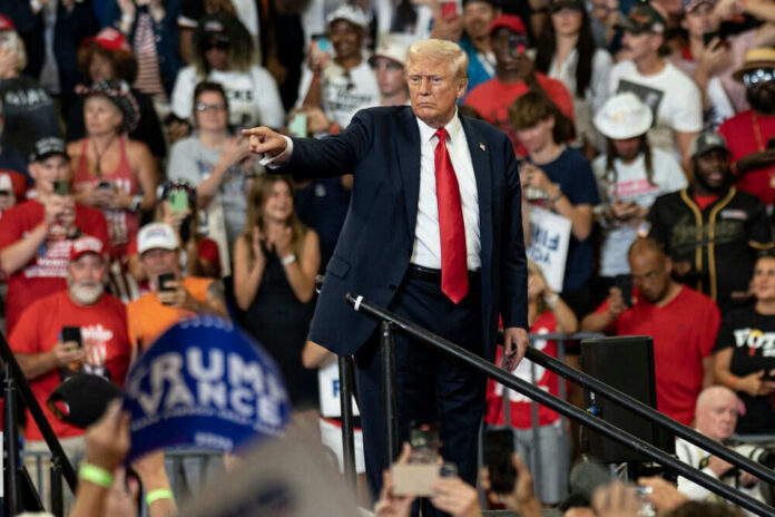 2499200151 Man pointing in front of cheering crowd at rally.