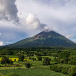 A majestic volcano surrounded by lush greenery and clouds
