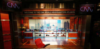 Interior of CNN World Headquarters studio with a red chair and glass desk