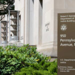 Exterior view of the Robert F. Kennedy Department of Justice Building with a sign