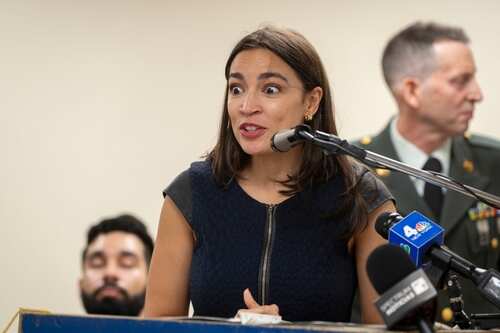 U.s.,Representative,Alexandria,Ocasio-cortez,Speaks,At,The,American,Legion,Boulevard A woman speaking passionately at a podium with a microphone