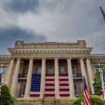 Historic building with large American flag and multiple flags in front