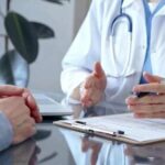 A doctor discussing with a patient over a clipboard in a medical office