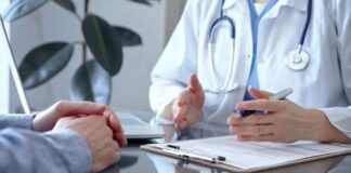 A doctor discussing with a patient over a clipboard in a medical office