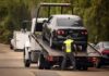 A tow truck lifting a black car onto its flatbed