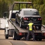 A tow truck lifting a black car onto its flatbed