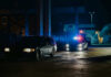 Hit-And-Run Horror: Teen Dead, Suspect Vanishes A police car with flashing lights parked next to a dark vehicle in a dimly lit urban area