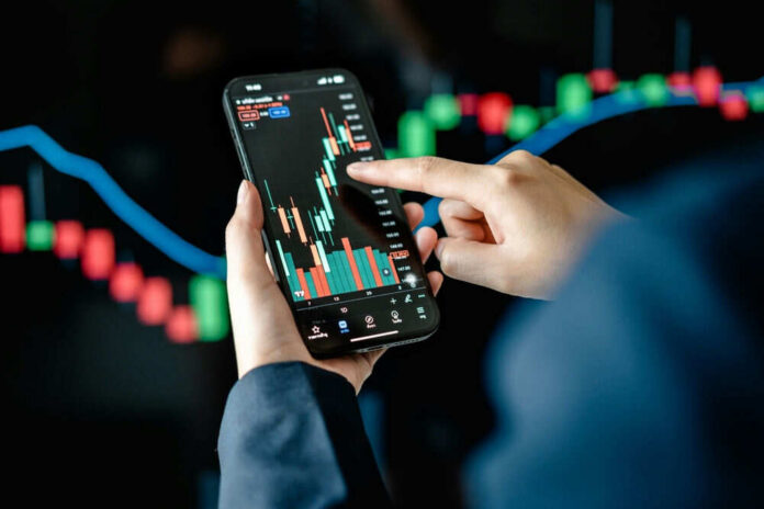 2453447349 Hands using smartphone displaying stock market data