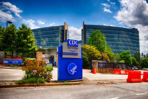 Signage of the CDC headquarters with modern buildings in the background
