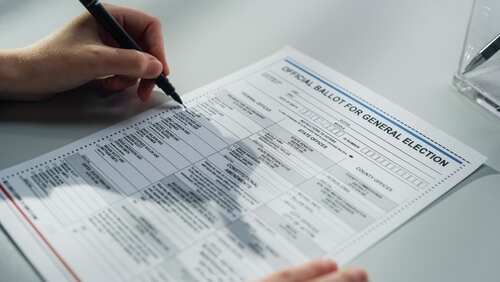 A person filling out an official ballot for a general election