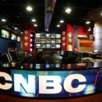 Interior of a CNBC news studio with multiple screens and a modern design