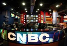 Whoopi’s Vote Warning Sparks Firestorm Interior of a CNBC news studio with multiple screens and a modern design