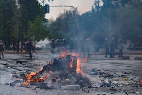 Santiago,De,Chile,,Region,Metropolitana,,Chile,15-11-2019:,A,Pile,Of A burning pile of debris in the street during a protest with police in the background