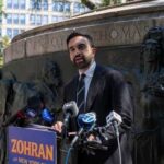 A man giving a speech at a podium in a city park